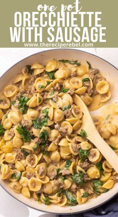 a skillet filled with pasta and sausage in a creamy, cheesy sauce