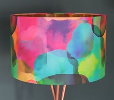 a colorful lamp shade with copper legs