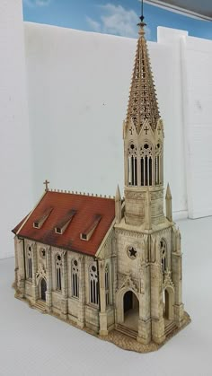 a model of a church with a red roof and steeple on it's side