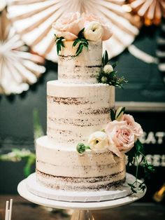 a three tiered cake with flowers on top