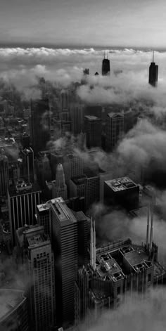 an aerial view of the city with skyscrapers and clouds in black and white photo