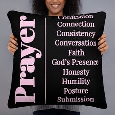 a woman holding up a pillow with the names of different people in pink on it