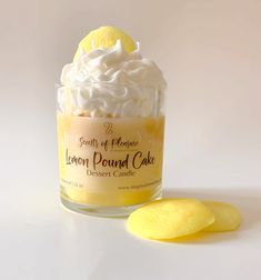 a lemon pound cake in a glass jar next to a slice of lemon on a white surface