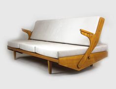 a wooden couch with white cushions on it