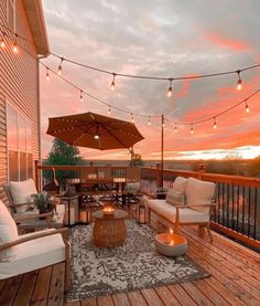 an outdoor deck with patio furniture and string lights