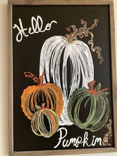 a chalkboard drawing of pumpkins with the word hello written in white on it