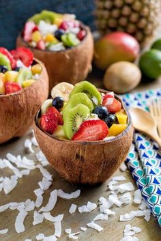 two wooden bowls filled with fruit on top of a table