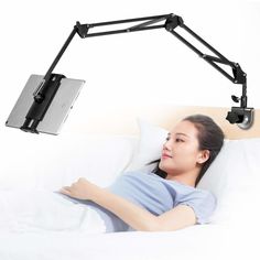 a woman laying in bed with her arm resting on the pillow under a desk lamp