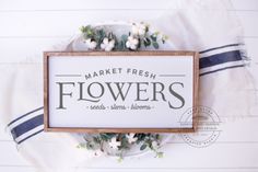 a sign that reads market fresh flowers sits on top of a plate with white flowers