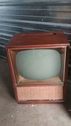 an old fashioned tv sitting on the ground