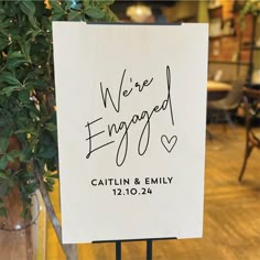 a sign that says we're engaged on it in front of a table with chairs