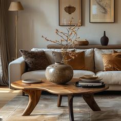 a living room with a couch, coffee table and pictures on the wall above it