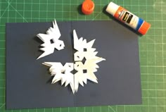 cut out snowflakes sitting on top of a piece of paper next to glue