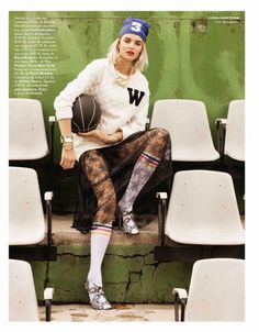 a woman sitting on the bleachers with a basketball in her hand and wearing tights