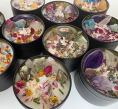 several bowls filled with different types of flowers and rocks on top of each other,