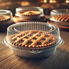 several pies in pans on a wooden table