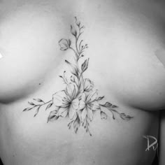 a black and white photo of a woman's breast with flowers on the side