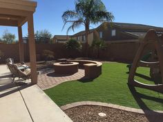 a backyard with artificial grass and an outdoor fire pit