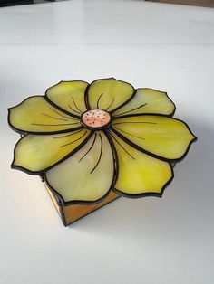 a stained glass flower sitting on top of a table