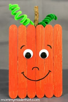 a carrot made out of pops sticks with googly eyes and a green leaf sticking out of it