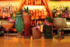 several different types of drinks are lined up on the bar