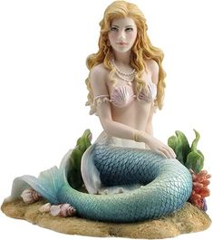 a statue of a mermaid sitting on top of a rock