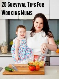 a woman holding a baby while standing in front of a blender filled with fruit