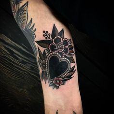 a woman's arm with a heart and flowers on it