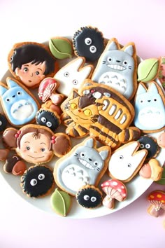 an assortment of decorated cookies on a white plate with various characters and animals around them