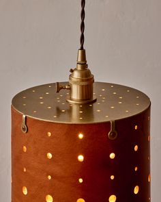 a light that is on top of a brown lamp shade with gold dots all over it