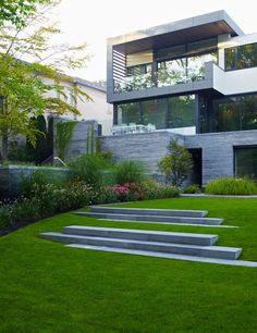 a modern house with grass and stairs leading up to it