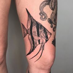 a woman's thigh with a fish tattoo on it