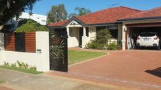 a car is parked in front of a house that has a driveway and two garages