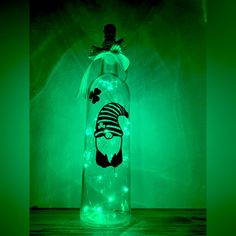 a glass bottle with some lights in the shape of a man's head on it