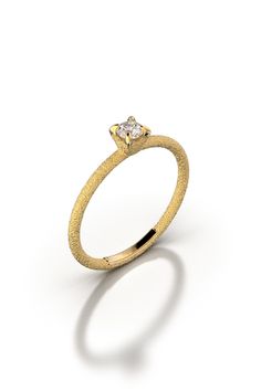 a yellow gold ring with a single diamond in the center, on a white background