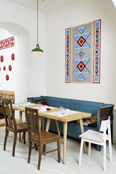 a living room filled with furniture next to a dining table and chairs in front of a painting on the wall