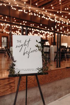 a sign that is on top of a tripod in front of some tables and chairs