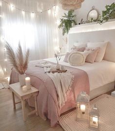 a bedroom decorated in pink and white with candles