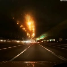 an image of a fire that is burning in the air on a highway at night