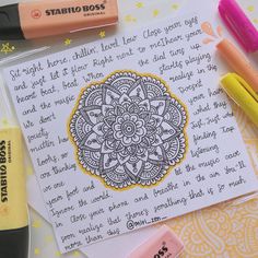 some markers and pens are laying on top of a piece of paper that has an intricate design