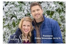 a man and woman standing next to each other in front of snow covered trees