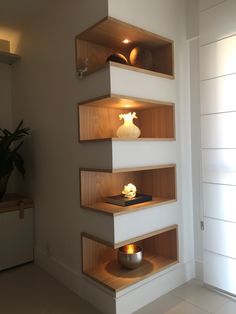 three wooden shelves in the corner of a room with light coming from above and below