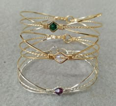 four different types of bracelets with stones on them, all in gold and silver