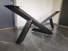 a metal sculpture sitting on top of a gray floor