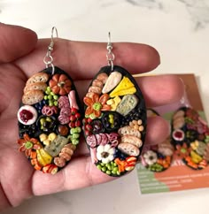 a pair of handmade earrings made out of food and vegetables is shown in front of a card