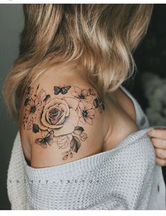 a woman's shoulder with flowers and butterflies tattooed on her left side ribcage