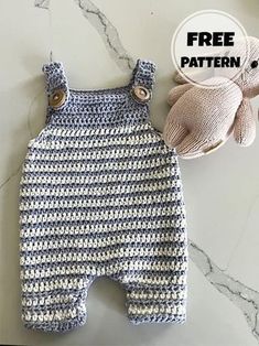 a crocheted baby romper and mitten are sitting on a marble surface