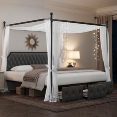 a bed with white drapes and lights on the headboard is in a bedroom