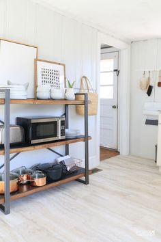 a kitchen with white walls and wooden floors