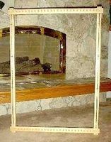 a large mirror sitting on top of a wooden bench in front of a stone wall